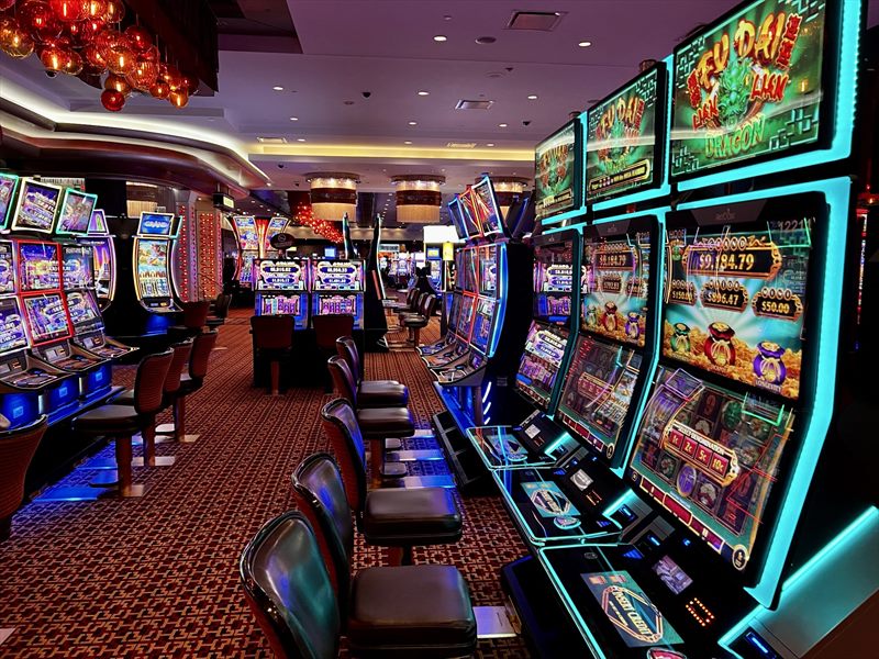 Pasillo de máquinas tragamonedas encendidas en la sala de un casino